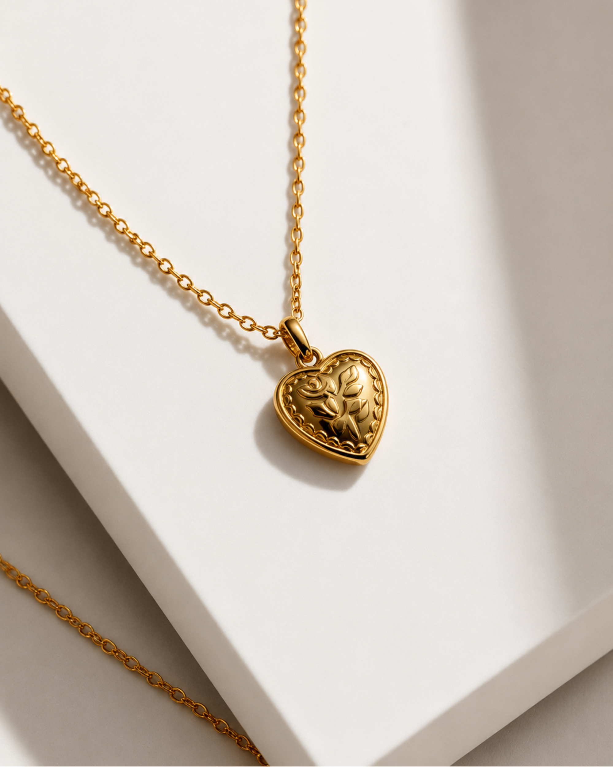 Gold heart-shaped pendant necklace on a white surface