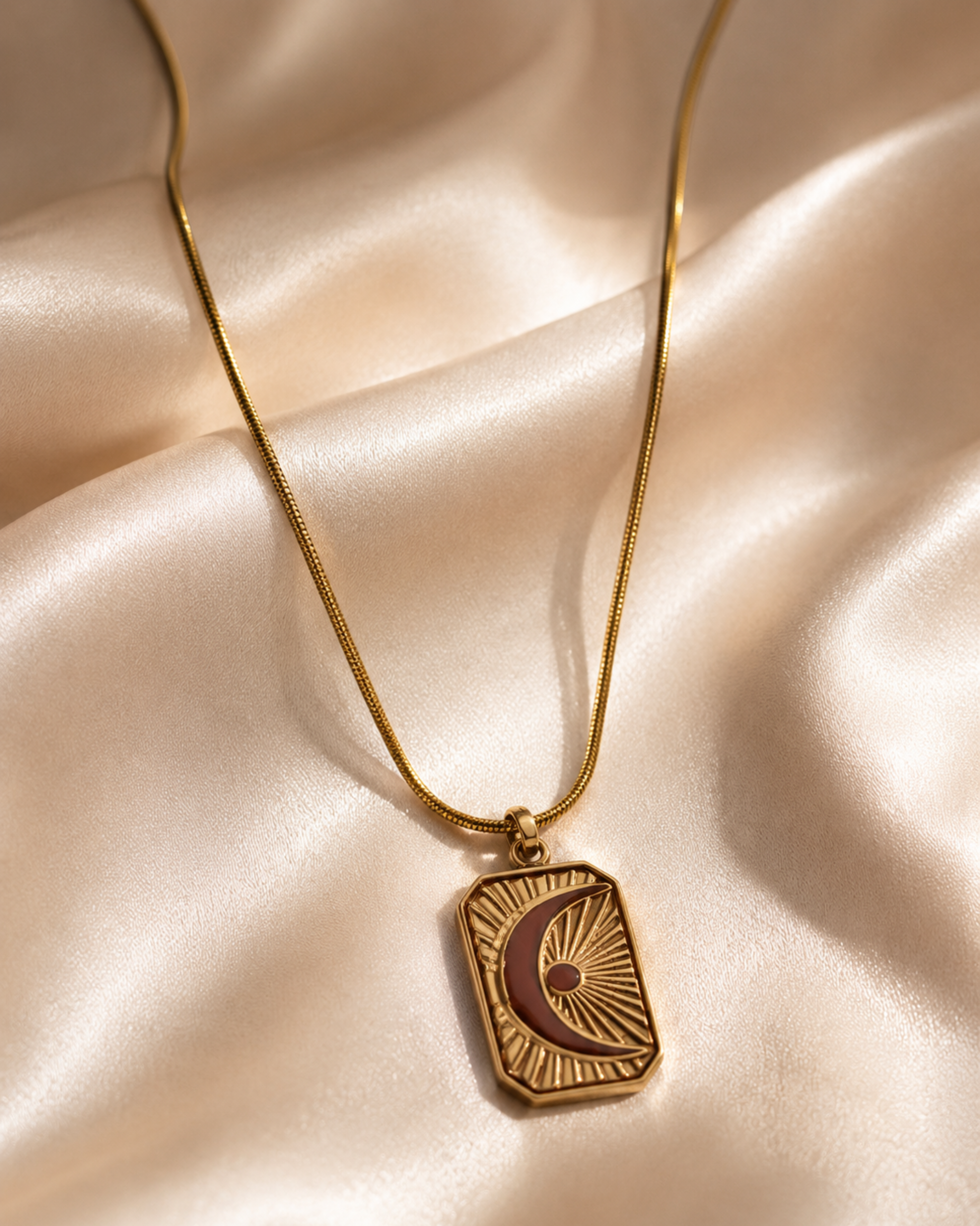 Gold necklace with a pendant on a beige fabric background